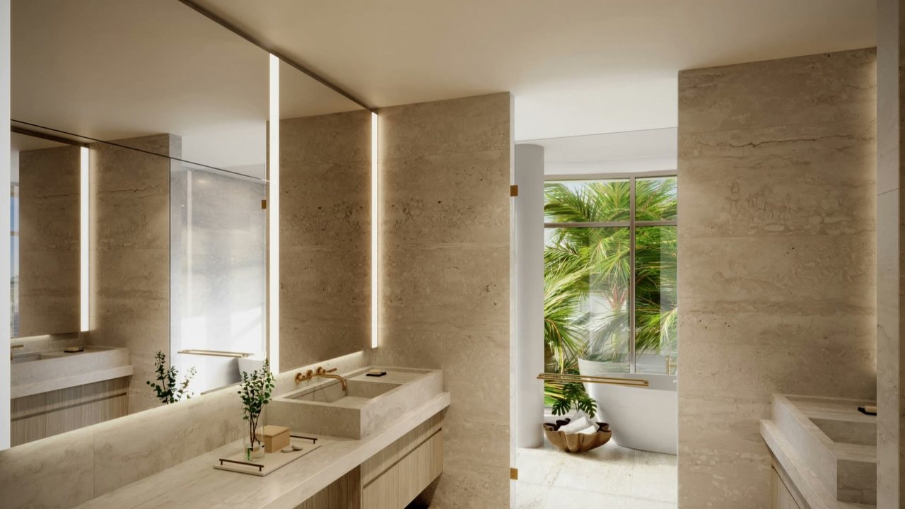 The primary bathroom, with stone vanities and a freestanding tub beyond.